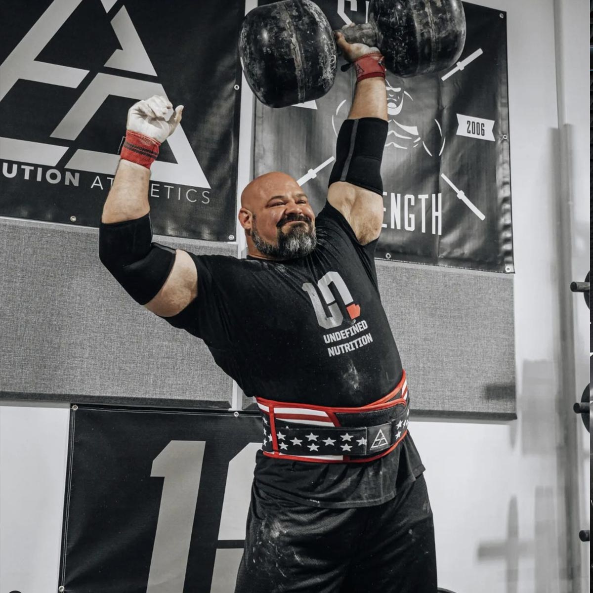 Brian Shaw lifting weights in a gym setting with 'Undefined Nutrition' branding.