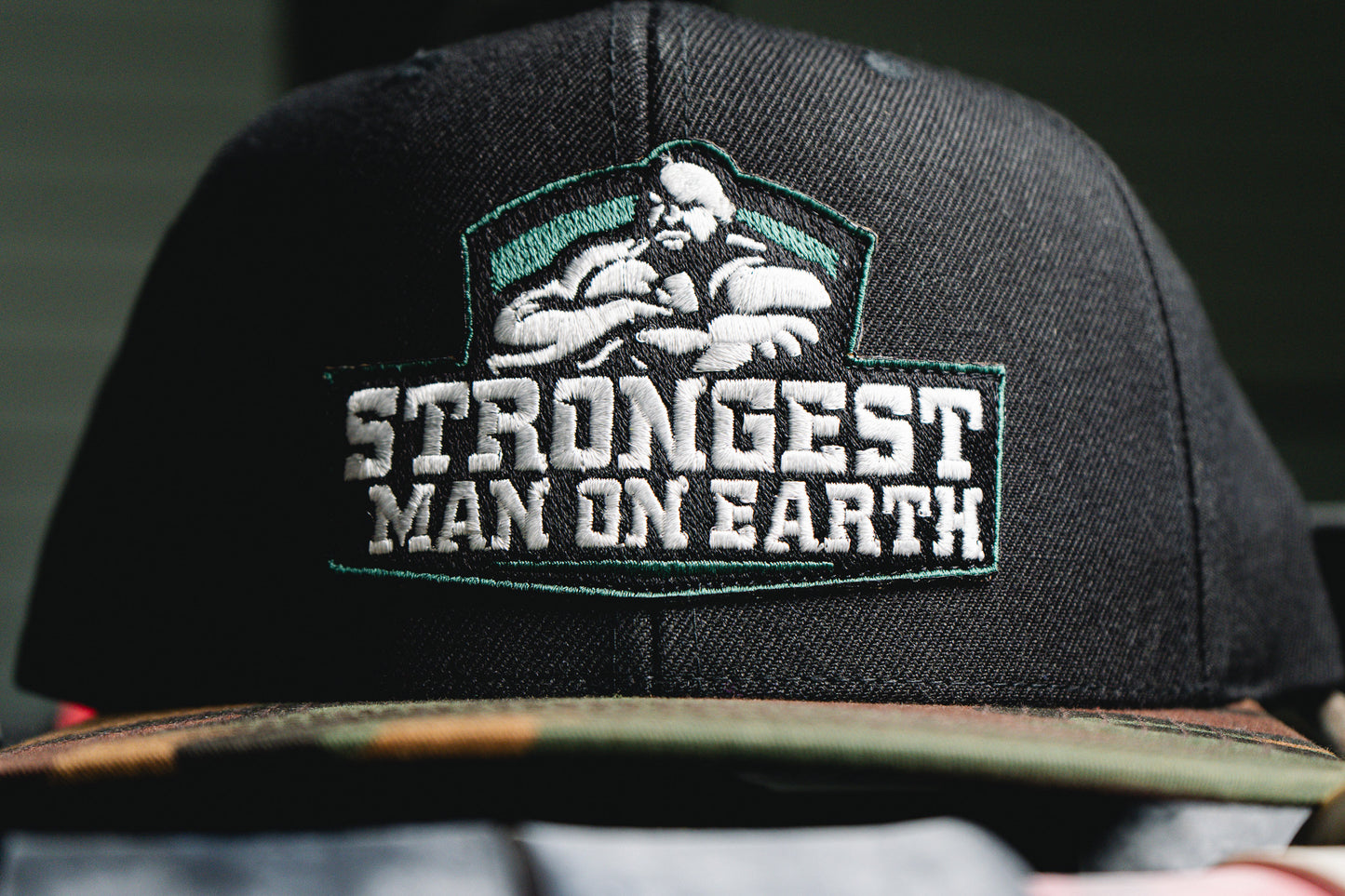 STRONGEST MAN ON EARTH SNAPBACK HAT