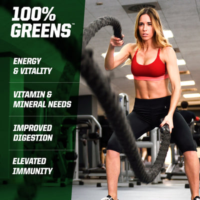 Woman using battle ropes in a gym with '100% Greens' supplement information on the left.