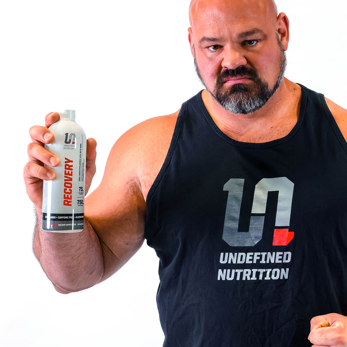 Brian Shaw holding a supplement bottle with 'Undefined Nutrition' branding